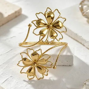 Close up detail of the gold metal open cuff bracelet featuring exquisite flower designs.