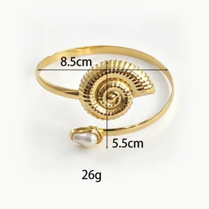 Detailopname van de gouden open armband met schelpontwerp en parel, inclusief maten.