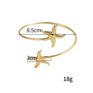 Brazalete de brazo abierto de estrella de mar dorada joyería de playa ajustable de metal.