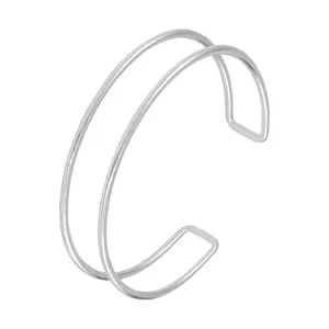 Detalle de pulsera brazalete de metal doble color plata, joya de brazo abierto minimalista.