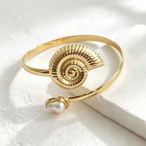 Detailopname van de gouden schelp open armband met parel, stijlvol strandontwerp.
