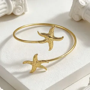 Detalle pulsera abierta de estrella de mar dorada moda playa verano vista de cerca primer plano