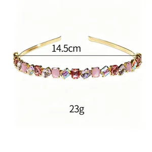 Close-up of gold metal headband decorated with colorful rectangular stones, detail.