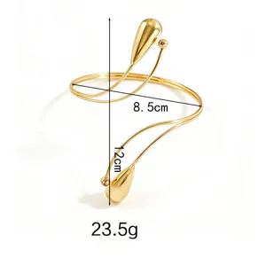 Primo piano dettagliato del bracciale da braccio a goccia dorato con dimensioni e curve.