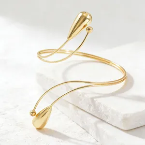 Bracciale da braccio aperto regolabile in metallo dorato, elegante gioiello minimalista.