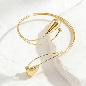 Bracciale da braccio aperto in metallo dorato con elegante design a goccia, gioiello chic.