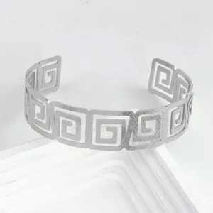 Vue détaillée du bracelet de bras ouvert géométrique argenté avec finition mate.