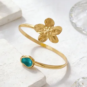 Detailansicht der eleganten goldenen Armspange mit strukturierter Blüte und Türkis.