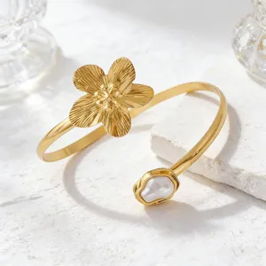 Exakter Metall Armreif mit offener Blume und einzigartiger barocker Perle als Detail.
