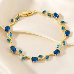 Close-up detail of the gold vine bracelet featuring sparkling blue cubic zirconia leaf stones.
