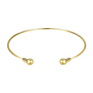 Brazalete abierto dorado con esferas elegante accesorio de moda punk minimalista.