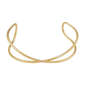 Brazalete abierto de metal dorado, diseño cruzado multicapa, detalle de joyería de moda punk.