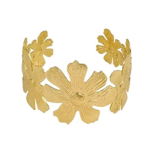 Gold metal open cuff bracelet with exaggerated flower design, chic hollow fashion jewelry.