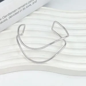 Vista di dettaglio di un bracciale rigido geometrico argentato minimalista, stile moderno.