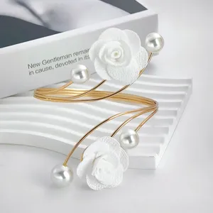 Elegant gold open arm cuff bracelet featuring white fabric roses and shiny pearls for women.