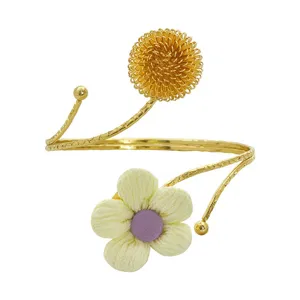 Exquisiter goldener offener Armreif mit drahtgewebter Blumenkugel und Stoffblume.