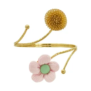 Modische goldene Metall-Armmanschette mit rosa Stoffblume und Drahtkugel, schickes Design.