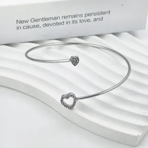 Zilveren open armband met dubbele kristallen en holle hartdetails voor vrouwen.
