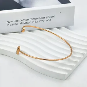 Elegante goudkleurige open manchetarmband met sprankelende strass dubbele hartdetails.