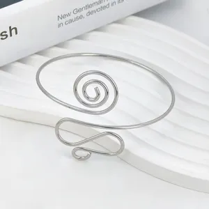 Primo piano dettagliato di un bracciale rigido aperto in metallo a spirale stile punk.