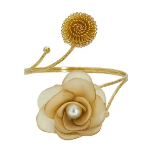 Nahaufnahme Detailaufnahme des goldenen Drahtblumen und Stoffperlen offenen Armreifs.