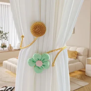 Eleganter Vorhanghalter aus Metall und Stoff mit Goldblume und grünem Blütendesign.