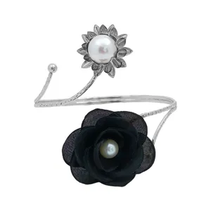 Detail view of adjustable metal curtain tieback featuring black fabric flower and pearl accents.