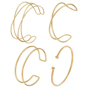 Nahaufnahme geometrischer goldener offener Draht Armreifen Set, minimalistischer Schmuck.