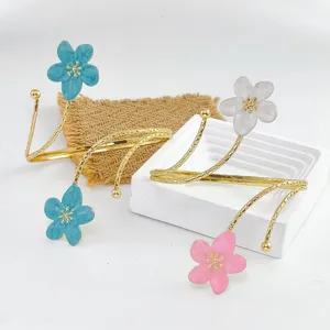 Vista detallada de pulseras abiertas con flores esmaltadas de colores, joyería elegante.