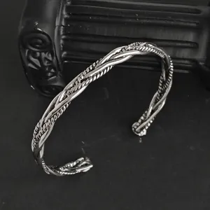 Vue détaillée du bracelet jonc ouvert en acier titane torsadé, design tressé rétro unisexe.