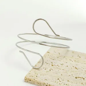 Dettaglio di un bracciale da braccio geometrico in metallo argentato lucido gioiello moda.