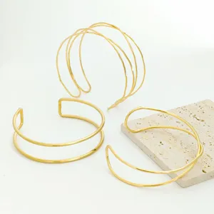 Detailed view of the multi-layer geometric gold open arm cuff bracelet with sleek shiny finish.