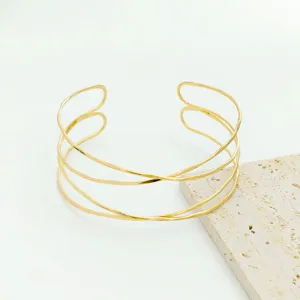Gold multi-layer crossed open cuff bracelet, chic fashion armlet jewelry detail view.