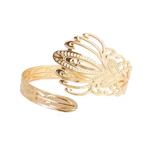 Primo piano del bracciale da braccio dorato vintage con disegno di piume per look elegante.