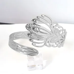 Bracciale da braccio aperto in metallo argentato con piuma, gioiello stile vintage.