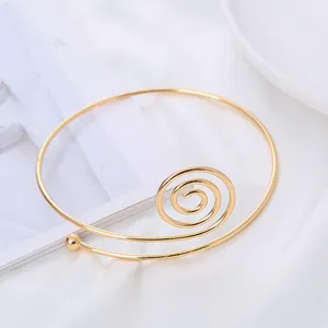 Bracciale rigido a spirale dorato minimalista con sferetta, design aperto elegante.