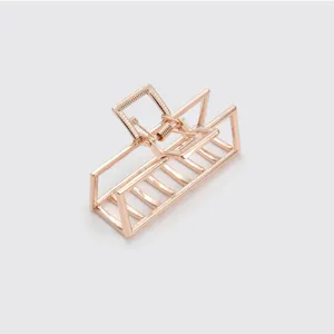 Detail shot of a rose gold geometric rectangular metal hair claw clip with hollow design.