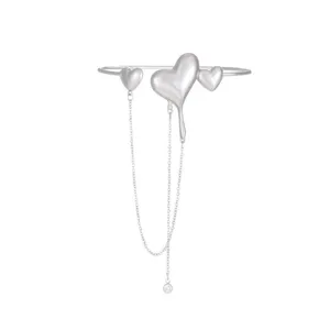 Bracciale rigido aperto in metallo argentato con cuori fusi e nappe a catena, gioiello alla moda.