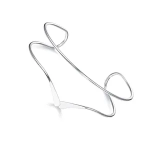 Primo piano del bracciale da braccio aperto in argento, con linee geometriche lisce e design.