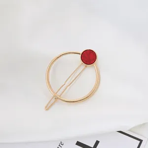 Pinza de pelo geométrica dorada elegante con detalle de mármol rojo, accesorio bonito.