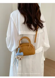 Minimalist brown boston shoulder bag for women, versatile PU leather crossbody bag with cute charm.