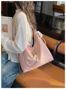 Vista dettagliata della borsa a spalla rosa con motivo di stelle e catena di perle.