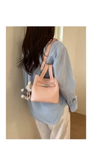Pink litchi grain bucket bag with metal lock, top handles and shoulder strap for women.