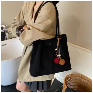 Large capacity black suede tote bag for women, stylish retro shoulder bag with cute pompom charms.