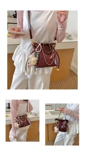 Fashion wine red quilted bucket bag with gold chain and cute bear charm for daily commute.
