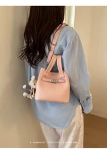 Pink leather bucket bag detail view, stylish shoulder handbag with cute bunny charm for daily wear.