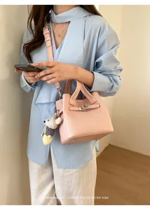 Chic pink leather handbag with top handle and cute koala charm for women daily fashion style.