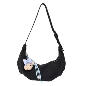 Trendy black croissant shoulder bag for women, casual crossbody bag with cute plush bear pendant.