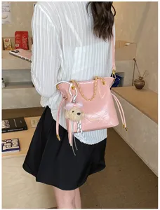 Stylish pink quilted shoulder bag with chain strap and cute bear charm for daily commuting.
