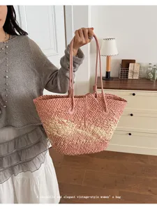Vue de détail d'un élégant sac cabas en paille tressée rose et beige vintage.